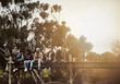 © SunriseDon/peopleimages.com - Sunset, lake and group of people on pier for fishing, outdoor adventure or winter holiday in nature. Fun, travel and happy friends on dock together for vacation, bonding or relax on bridge in forest
