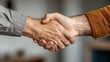 ©  Jovaduplex - Close view of two hands meeting in a firm handshake, focusing on trust and agreement aspect, emphasizing human connection in a neutral setting for collaboration context.