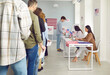 © Studio Romantic - American voters at the polling station. Group of young people standing in line at the polling station during the election in the United States of America