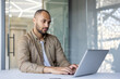 © Liubomir - Professional man using laptop in office setting, showing concentration on work tasks. Modern workspace highlights focus, technology, and business environment.