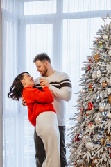 Wall Mural - lovely couple dancing in front of christmas tree