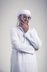 Handsome man with traditional white kandura from uae. Studio portraits with Dubai outfit about fashion and lifestyle