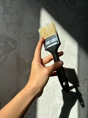 paint brush in a woman's hand close-up. renovation aesthetics