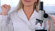 © Евгения Медведева - Female laboratory assistant analyzes samples using a microscope while working at a table in a laboratory, doing research