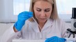 © Евгения Медведева - female scientist laboratory assistant uses micropipettes to fill test tubes in a large modern laboratory, for examination under a microscope.