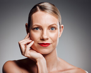 Poster - Portrait, beauty and mature woman in makeup for glow, skincare results or dermatology. Face, touch and model with red lipstick for cosmetics, anti aging and aesthetic at spa on gray studio background