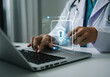 © Hanna - A healthcare professional using a laptop with a focus on cybersecurity in a modern medical office setting