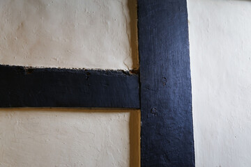 A close up view of the wood framing and plaster on an old 15th century wall in an English cottage.