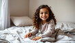 © Sergey - Photo of positive smiling girl sit bed duvet touch curls hair look in indoors room interior isolated with white highlights, png