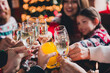 © deagreez - Cropped photo of group family members clink champagne juice gather celebrate christmas apartment indoors