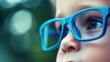 © Steve - Young child wearing blue glasses focusing on distant tree outside window, symbolizing myopia prevention and importance of outdoor activities.