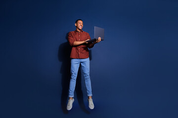 Poster - Full length photo of funky cool guy dressed brown shirt jumping high chatting device emtpy space isolated blue color background