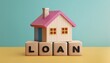© Nim9ty  Pics - A miniature house model with the word 'LOAN' displayed on wooden blocks, symbolizing home financing and mortgage solutions.