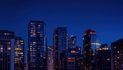 City skyline illuminated at night with towering buildings and a dark blue sky