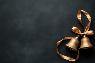 Two elegant gold bells with ribbons on a dark background.