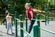 © caftor - Senior man pulls up on crossbar in city park on sports ground