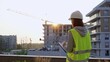 © volha_r - Construction female engineer taking notes and writing on clipboard while inspecting a building site