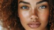 © Sergio - Close-up portrait of a woman with curly hair and freckles, showcasing her captivating blue eyes and natural beauty indoors
