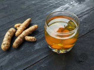 Turmeric solution and fresh turmeric on a wooden table. Healthy food lifestyle, Herb mendicine plant 