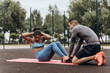 © Maria Vitkovska - Active African American woman doing abs training together with personal trainer on the street