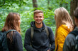 © Michael - Young man hiking with friends smiling in the forest