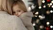 © Wimon - A candid Christmas morning moment where a mother and child share an affectionate embrace by the tree.