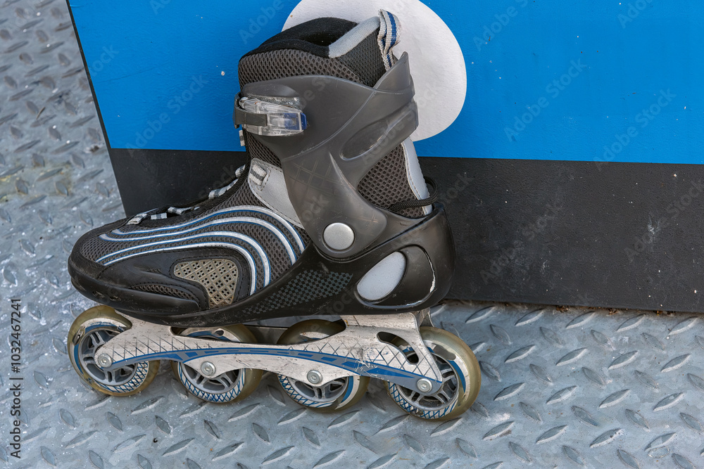 roller skate shoe stands outside against a black and blue steel box