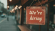 © Meritxell Cid - A red sign hanging from a window that says 'We're hiring'