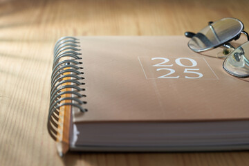 eyeglasses on top of  2025 brown diary.