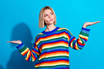 Photo of nice young woman think hands hold empty space wear striped sweater isolated on blue color background