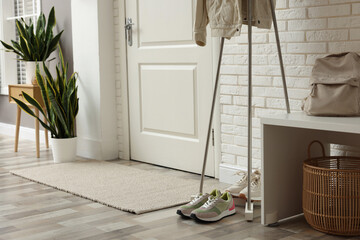 Wall Mural - Metal rack with jacket and sneakers in hallway