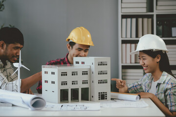 Wall Mural - team of architects is examining a building model and discussing plans while working together in thei