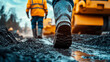 © Alina Tymofieieva - Worker walks on a construction site with heavy machinery in the background during sunset hours