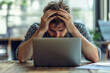 © Denis - Despair stressed out young male businessman employee showing frustration holding his head with hands, job working on laptop against modern office background, corporate concept.