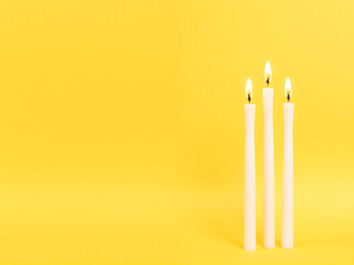 burning candles on a yellow background