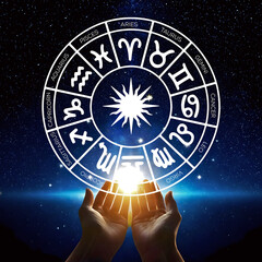 the zodiac wheel in the palm of hand with bright stars in the dark night. design according to the ho