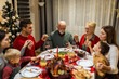 © Mediteraneo - Family praying before eating tasty homemade food. Christmas dinner. Christmas decorations