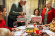 © Mediteraneo - Grandparents giving presents to their grandchildren on Christmas Eve. Family having dinner.