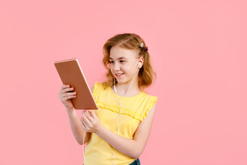 A teenage girl does her homework on a tablet. The student works and communicates with friends on Pink background