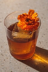 Beautiful Orange Cocktail with Ice and Flower Garnish