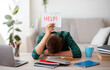 © Prostock-studio - Exhausted schooler asking for help with help placard, studying online from home, difficulties of e-education