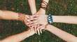 © Prostock-studio - United hands of young females, top view. Stylish hands of girlfriends in boho hippie bracelets at green grass background. Togetherness and support, youth fashion and active lesiure. Women friendship