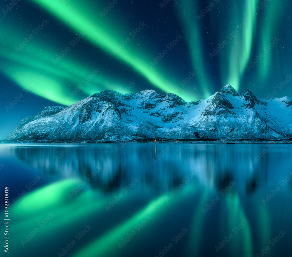 Northern lights over the snowy mountains, sea coast, reflection in ...