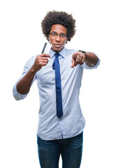 Wall Mural - Afro american man holding credit card over isolated background pointing with finger to the camera and to you, hand sign, positive and confident gesture from the front