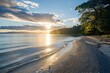 © Prism Trail - Tranquil Beach Scene with a Golden Sunset Over the Ocean
