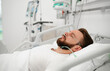 © My Ocean studio - A close-up of a male patient lying in a hospital bed with an oxygen tube, surrounded by medical equipment in the background, highlighting patient care, recovery, and a clinical healthcare setting.