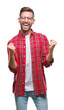 © Krakenimages.com - Young handsome man over isolated background very happy and excited doing winner gesture with arms raised, smiling and screaming for success. Celebration concept.