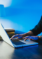 Close-up of male hands with laptop. Man is working remotely at home. Freelancer at work