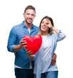 © Krakenimages.com - Young couple in love holding red heart over isolated background with happy face smiling doing ok sign with hand on eye looking through fingers