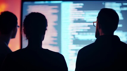 Aufkleber - Three software developers work intensely on code in a dim office, showcasing their expertise in programming and web development